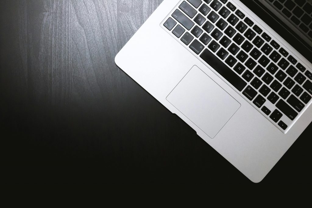 ordinateur portable posé sur un bureau sombre