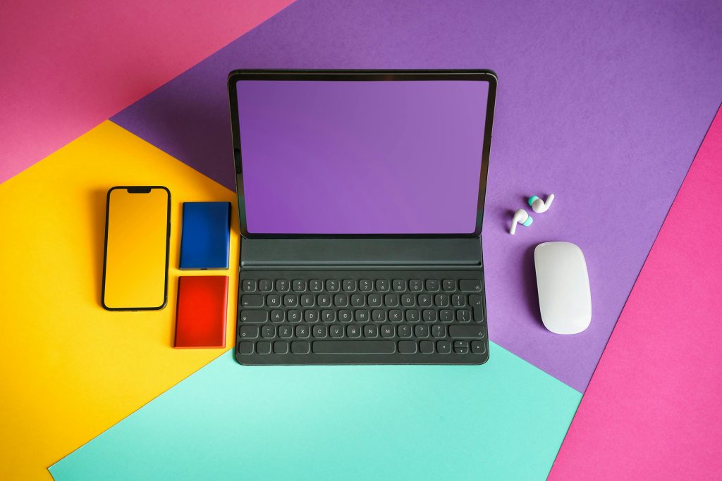 Image aérienne d'un ordinateur portable, d'un smartphone et d'autres accessoires sur fond de couleur très flashy