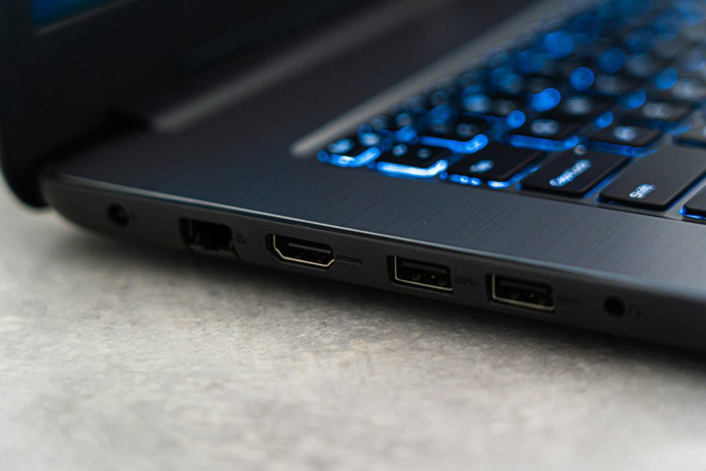 Gros plan sur un ordinateur portable gamer émettant une lumière bleue, mettant en valeur son écran et son clavier.